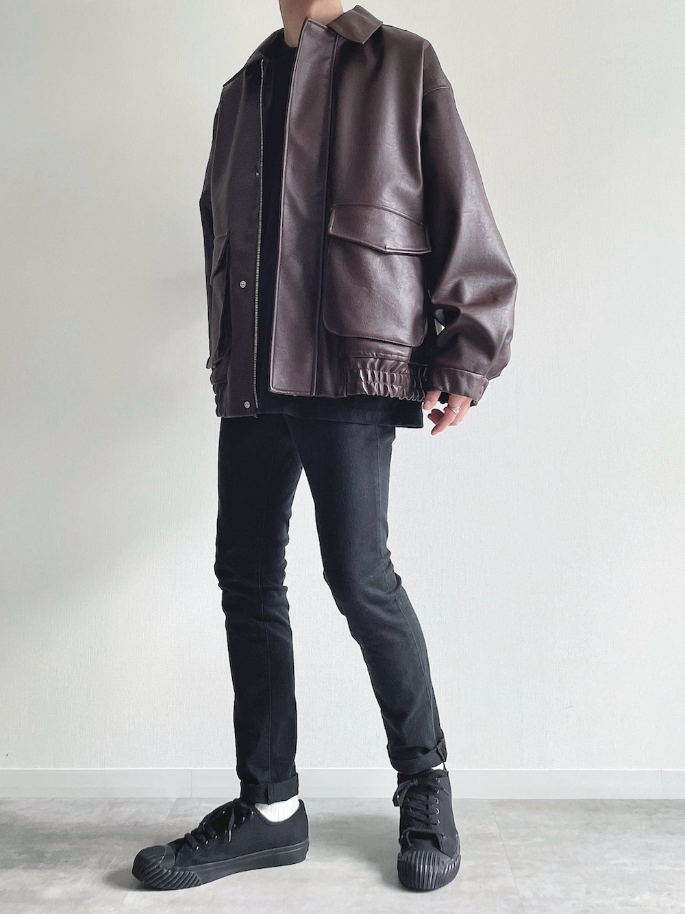 ブラウン系のブルゾン、ブラック系のTシャツ/カットソー、ブラック系のパンツを着用したメンズの冬コーディネートの3枚目の写真