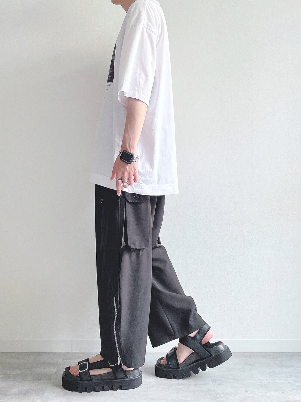 ホワイト系のTシャツ/カットソー、ブラック系のカーゴパンツ、ブラック系のサンダルを着用したメンズの夏コーディネートの3枚目の写真