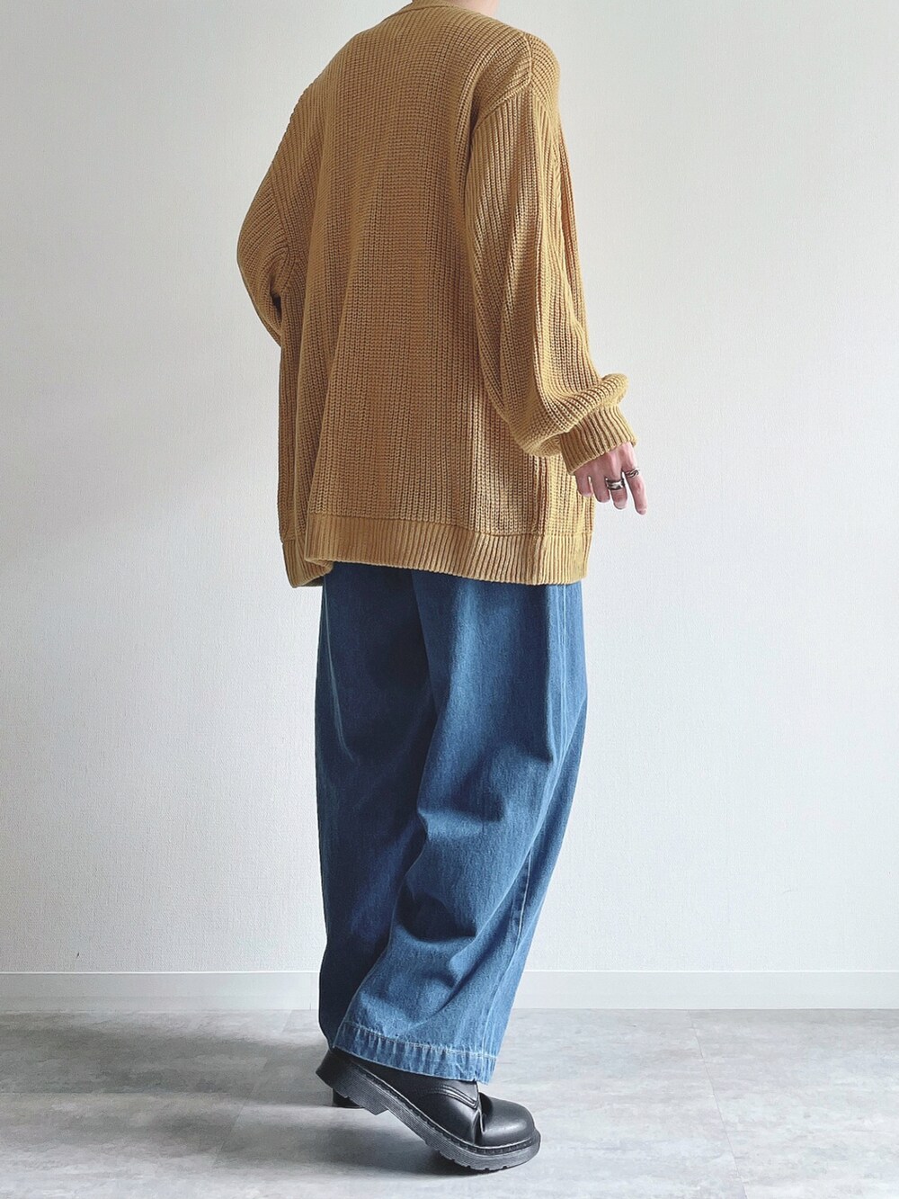 イエロー系のカーディガン/ボレロ、ホワイト系のTシャツ/カットソー、ブルー系のデニムパンツを着用したメンズの秋コーディネートの4枚目の写真