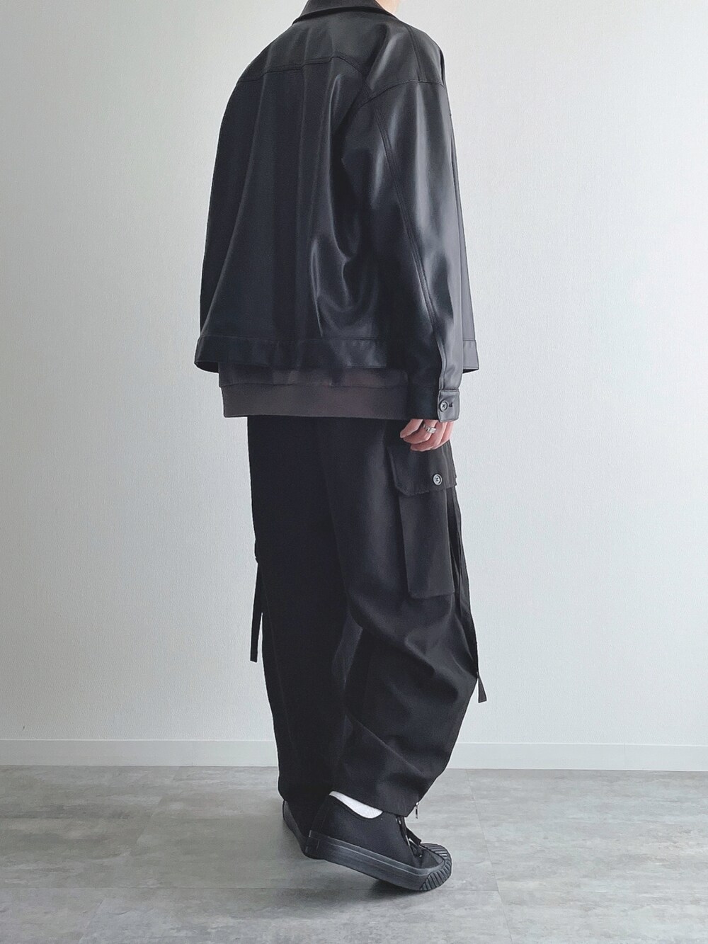 ブラック系のブルゾン、グレー系のトップス、ブラック系のカーゴパンツを着用したメンズの秋コーディネートの3枚目の写真