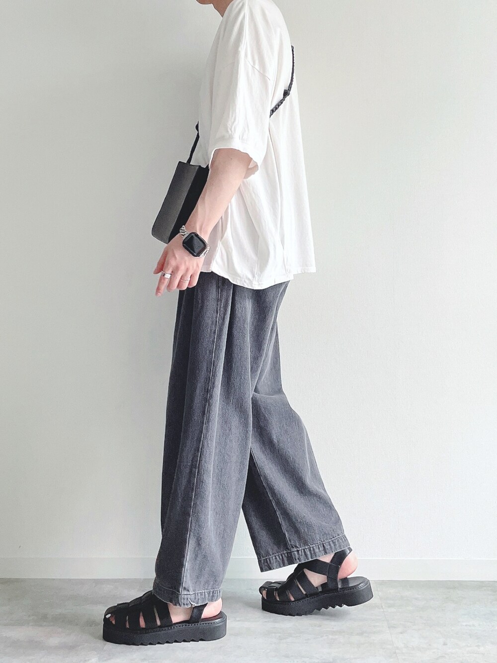 ホワイト系のTシャツ/カットソー、ブラック系のデニムパンツ、ブラック系のサンダルを着用したメンズの夏コーディネートの2枚目の写真