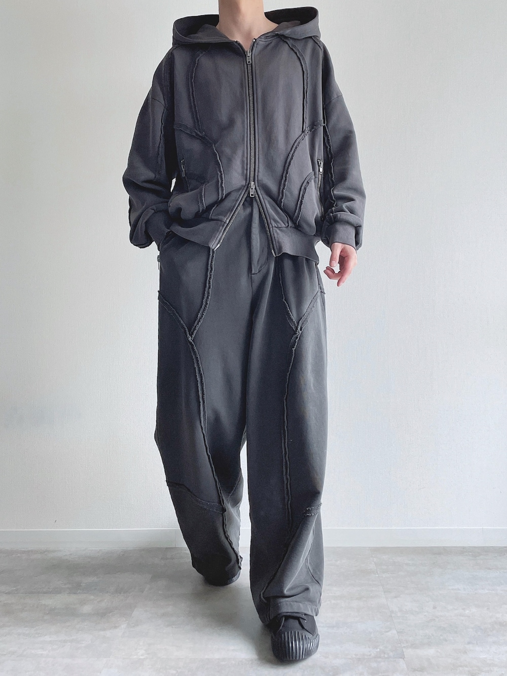 グレー系のパーカー、グレー系のスウェットパンツ、ホワイト系のタンクトップを着用したメンズの春コーディネートの3枚目の写真