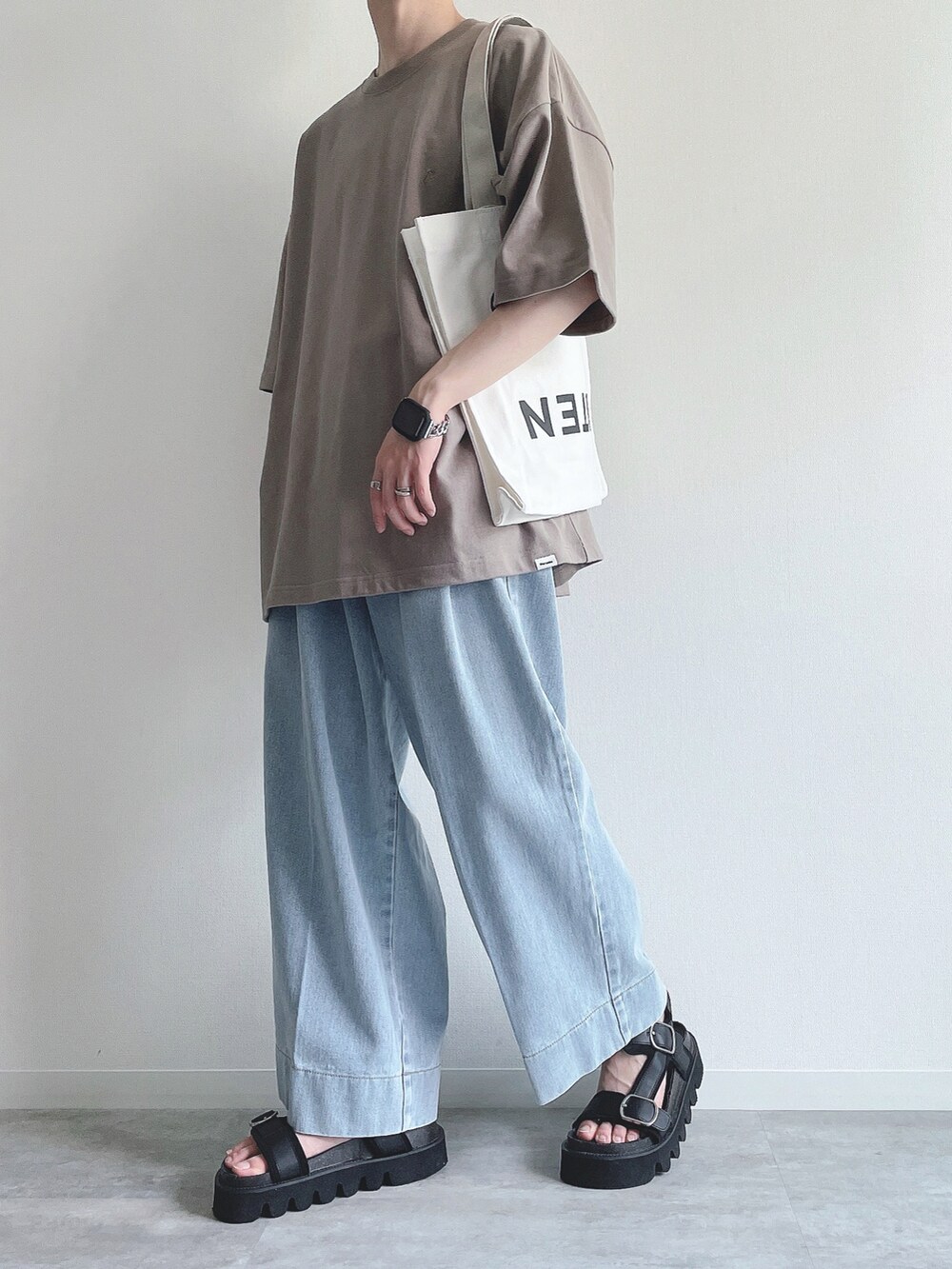 ベージュ系のTシャツ/カットソー、ブルー系のデニムパンツ、ブラック系のサンダルを着用したメンズの夏コーディネートの5枚目の写真