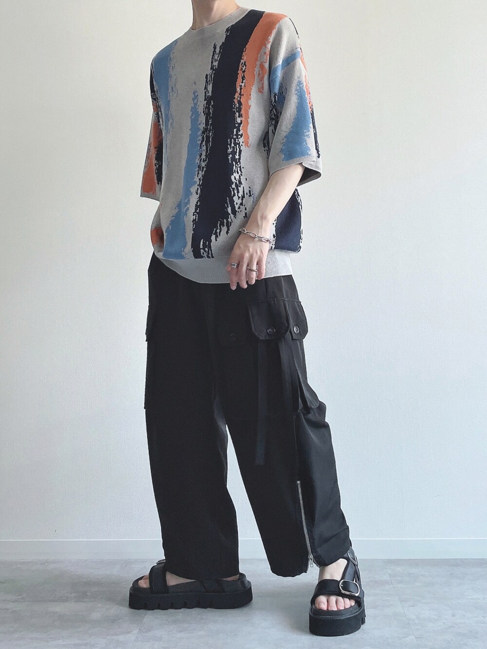 グレー系のニット/セーター、ブラック系のカーゴパンツ、ブラック系のサンダルを着用したメンズの夏コーディネートの5枚目の写真