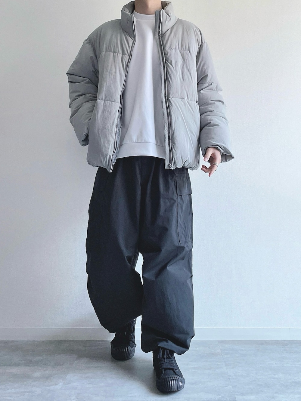 グレー系のダウンジャケット/コート、ホワイト系のトップス、ブラック系のカーゴパンツを着用したメンズの冬コーディネートの2枚目の写真