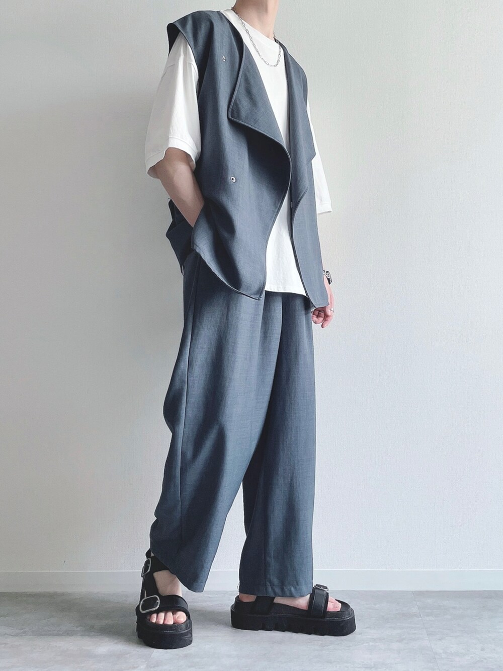 ブルー系のベスト、ホワイト系のTシャツ/カットソー、ブルー系のスラックスを着用したメンズの春コーディネートの4枚目の写真