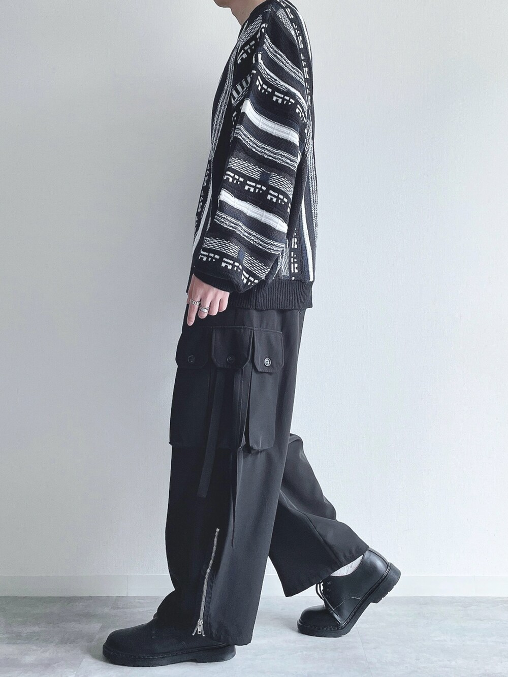 ブラック系のニット/セーター、ブラック系のカーゴパンツ、ブラック系のスニーカーを着用したメンズの秋コーディネートの3枚目の写真