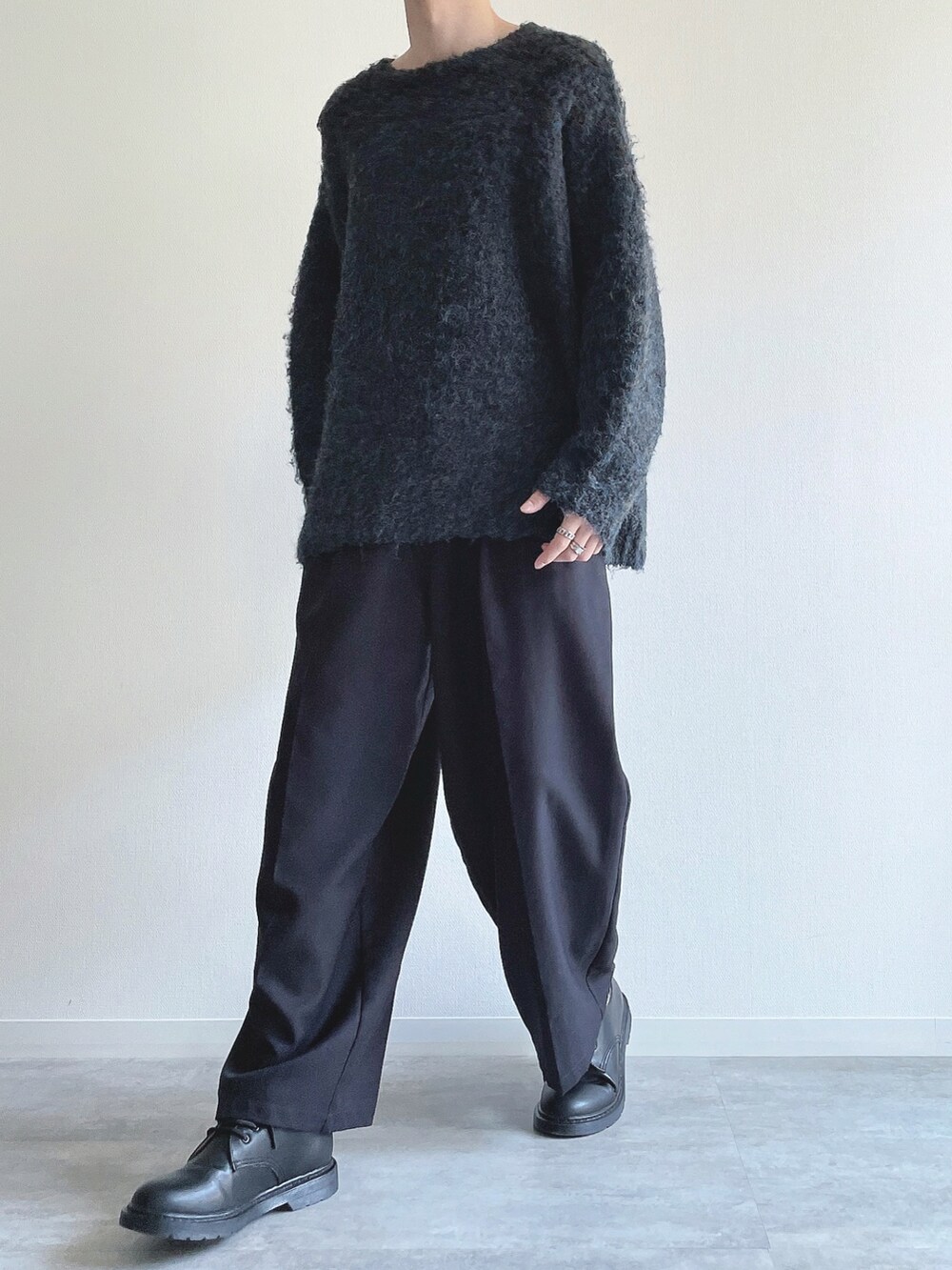 ブルー系のニット/セーター、ブラック系のスラックス、ブラック系のシューズを着用したメンズの秋コーディネートの5枚目の写真