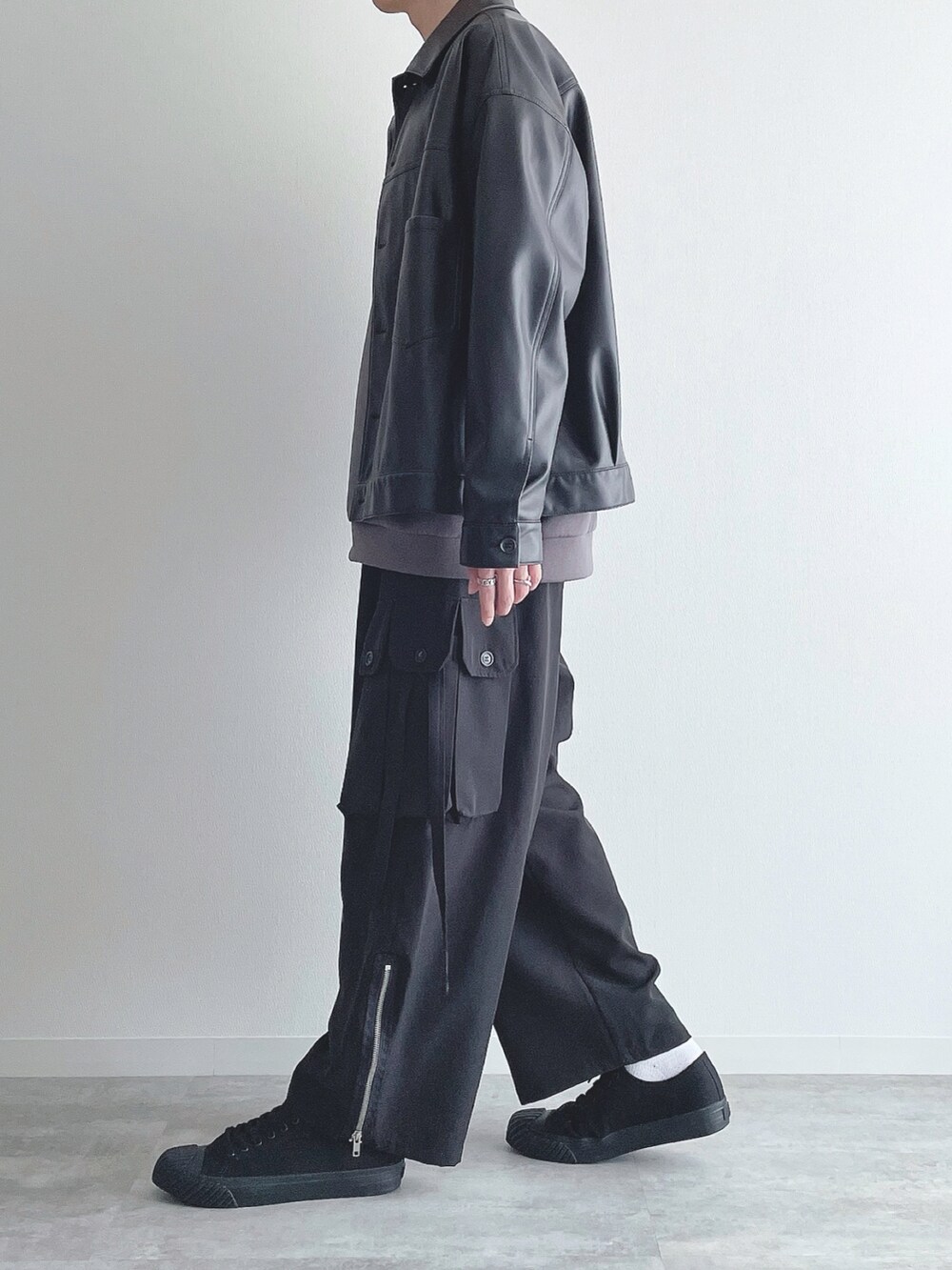 ブラック系のブルゾン、グレー系のトップス、ブラック系のカーゴパンツを着用したメンズの秋コーディネートの2枚目の写真