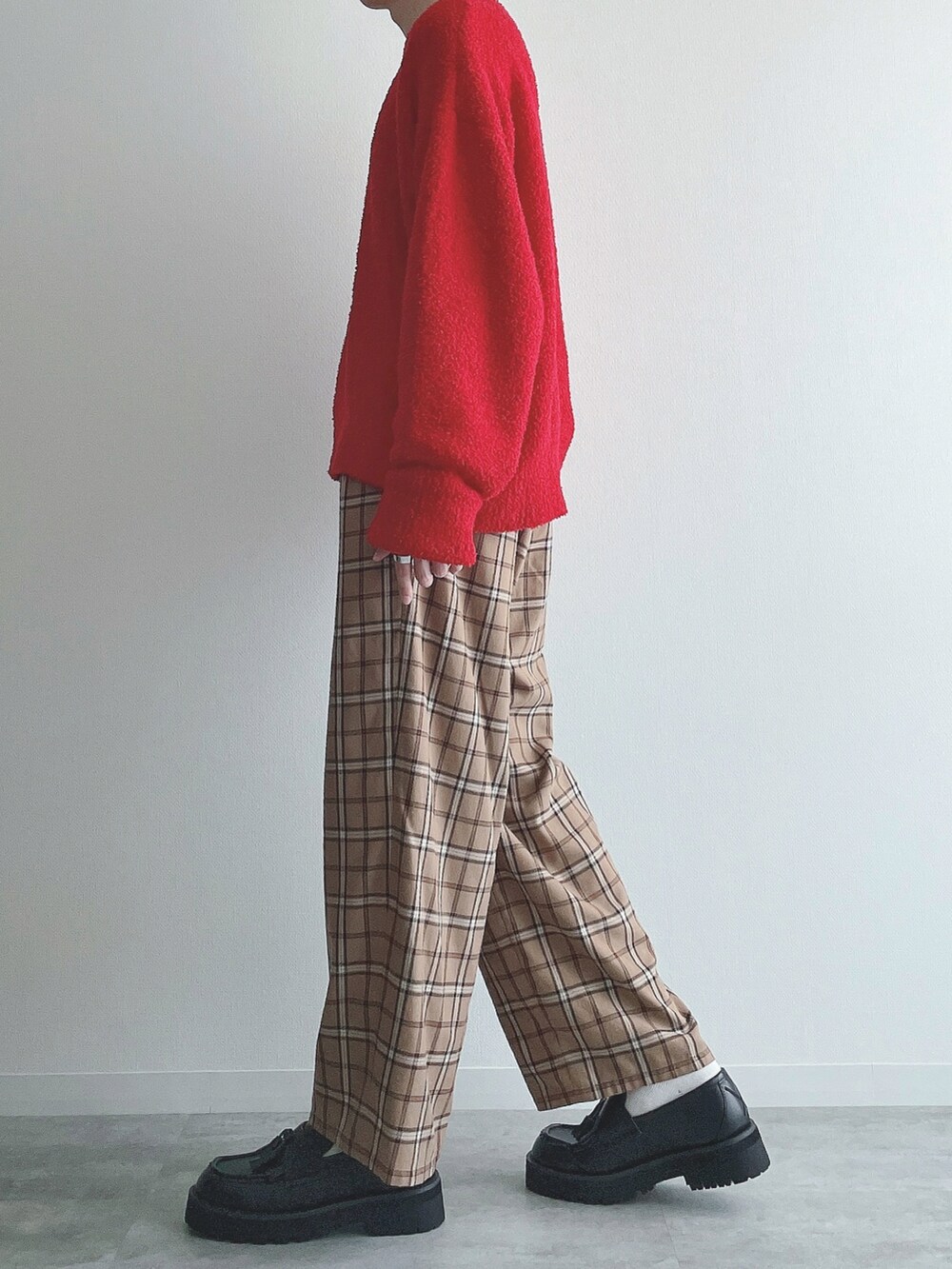 レッド系のニット/セーター、ベージュ系のその他パンツ、ブラック系のローファーを着用したメンズの秋コーディネートの2枚目の写真