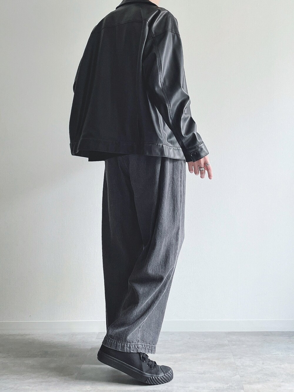 ブラック系のブルゾン、ブラック系のTシャツ/カットソー、ブラック系のデニムパンツを着用したメンズの秋コーディネートの4枚目の写真