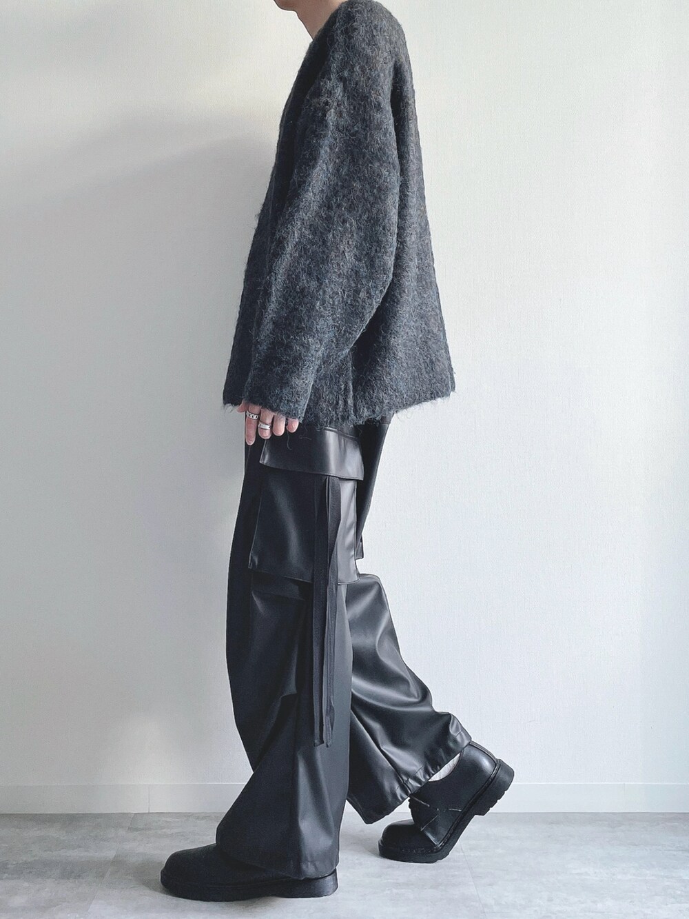 ブルー系のニット/セーター、ブラック系のカーゴパンツ、ブラック系のシューズを着用したメンズの冬コーディネートの3枚目の写真