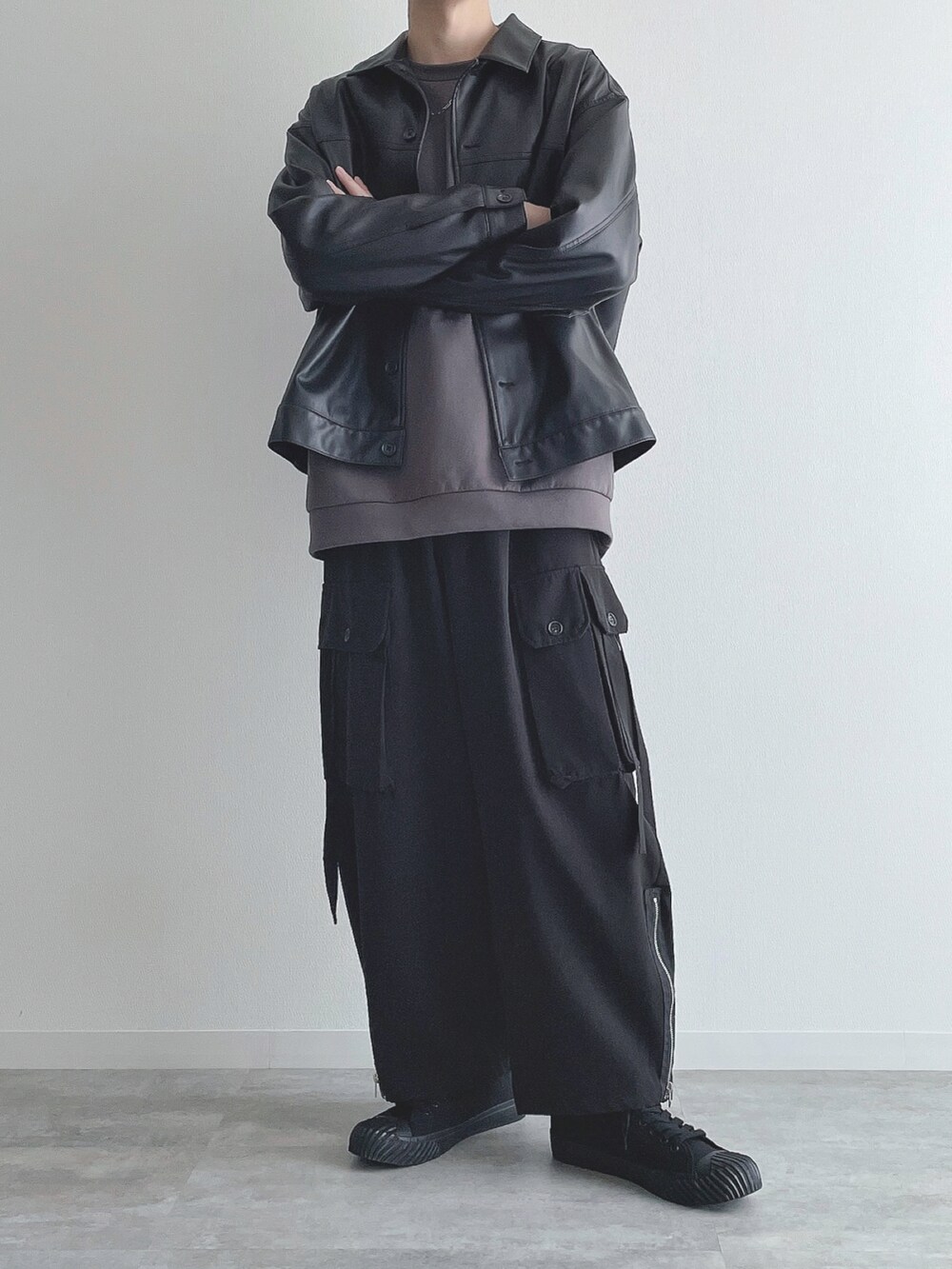 ブラック系のブルゾン、グレー系のトップス、ブラック系のカーゴパンツを着用したメンズの秋コーディネートの4枚目の写真