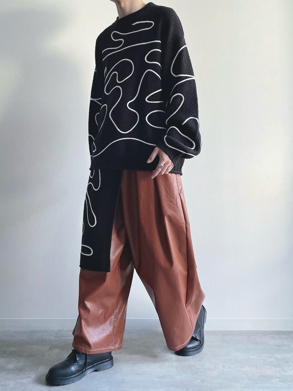 ブラック系のニット/セーター、ブラック系のスカート、ブラウン系のその他パンツを着用したメンズの冬コーディネートの5枚目の写真