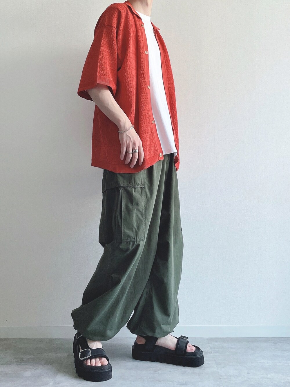 オレンジ系のシャツ/ブラウス、ホワイト系のTシャツ/カットソー、グリーン系のカーゴパンツを着用したメンズの夏コーディネートの2枚目の写真