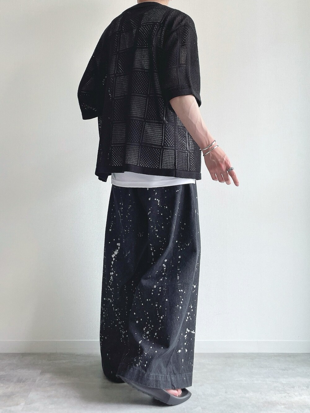 ブラック系のトップス、ホワイト系のタンクトップ、ブラック系のデニムパンツを着用したメンズの夏コーディネートの4枚目の写真