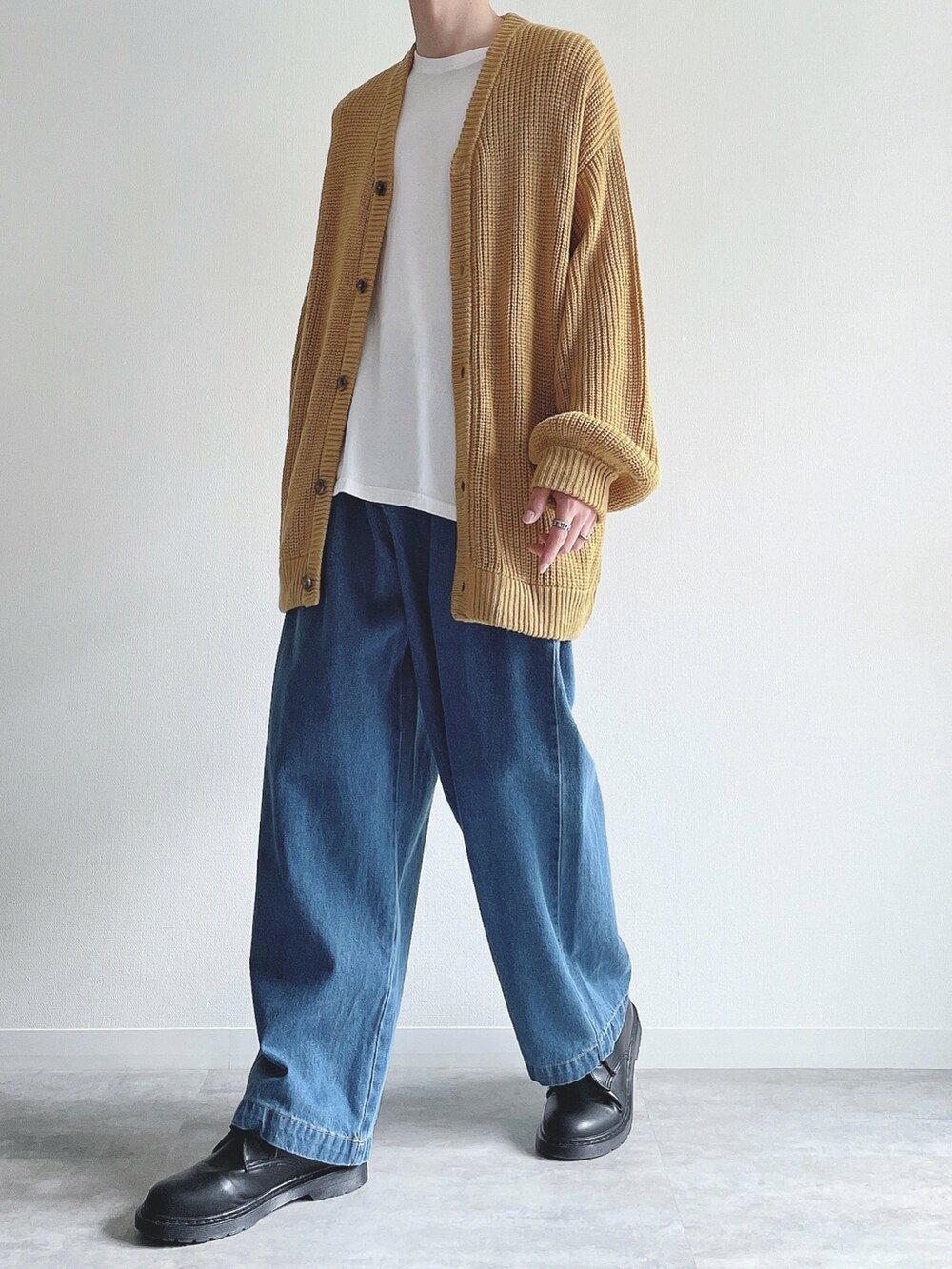 イエロー系のカーディガン/ボレロ、ホワイト系のTシャツ/カットソー、ブルー系のデニムパンツを着用したメンズの秋コーディネートの5枚目の写真