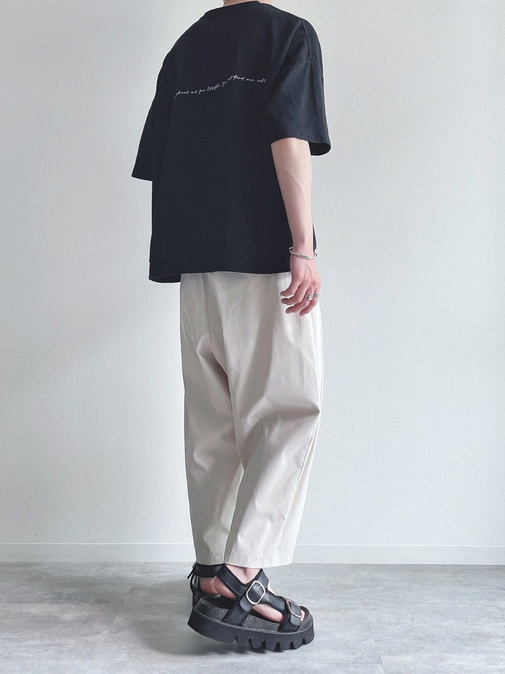 ブラック系のTシャツ/カットソー、ホワイト系のその他パンツ、ブラック系のサンダルを着用したメンズの夏コーディネートの3枚目の写真