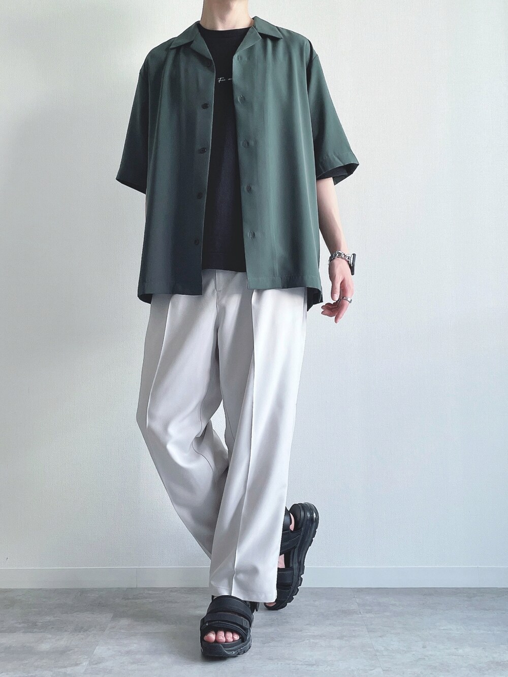 グリーン系のトップス、ブラック系のTシャツ/カットソー、ホワイト系のスラックスを着用したメンズの夏コーディネートの5枚目の写真