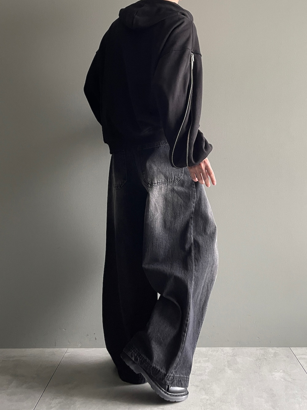 ブラック系のパーカー、ブラック系のデニムパンツ、ホワイト系のTシャツ/カットソーを着用したメンズの冬コーディネートの3枚目の写真