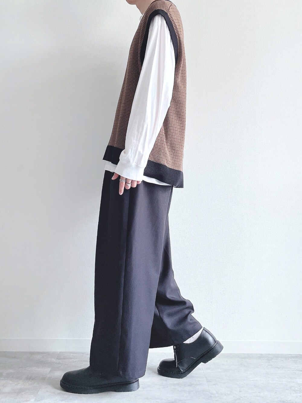 ホワイト系のTシャツ/カットソー、ブラウン系のトップス、ブラック系のスラックスを着用したメンズの秋コーディネートの3枚目の写真