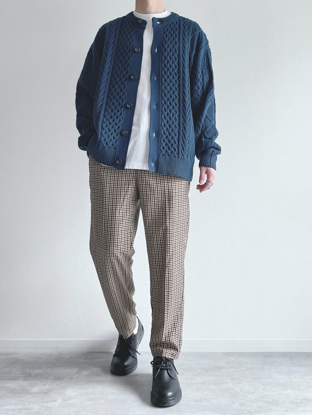 ブルー系のトップス、ホワイト系のTシャツ/カットソー、ブラウン系のスラックスを着用したメンズの冬コーディネートの2枚目の写真