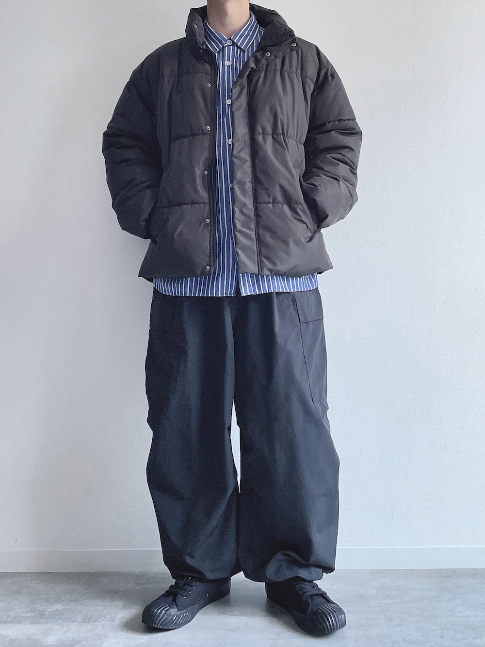 ブラック系のダウンジャケット/コート、ブルー系のシャツ/ブラウス、ブラック系のカーゴパンツを着用したメンズの冬コーディネートの5枚目の写真