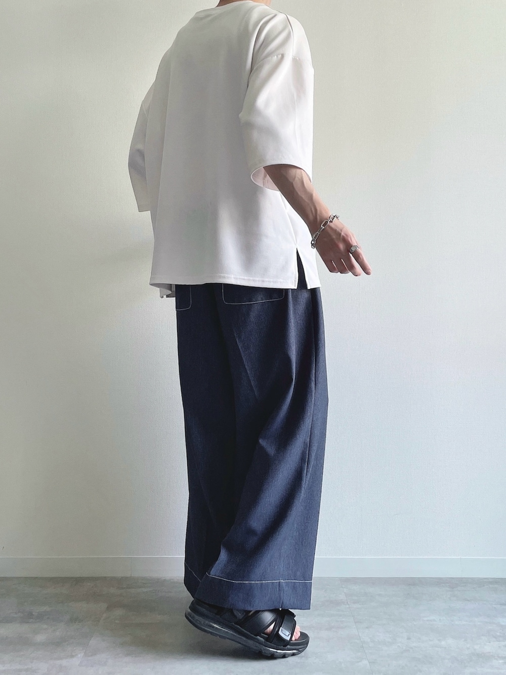 ホワイト系のTシャツ/カットソー、ブルー系のデニムパンツ、ブラック系のシューズを着用したメンズの夏コーディネートの3枚目の写真