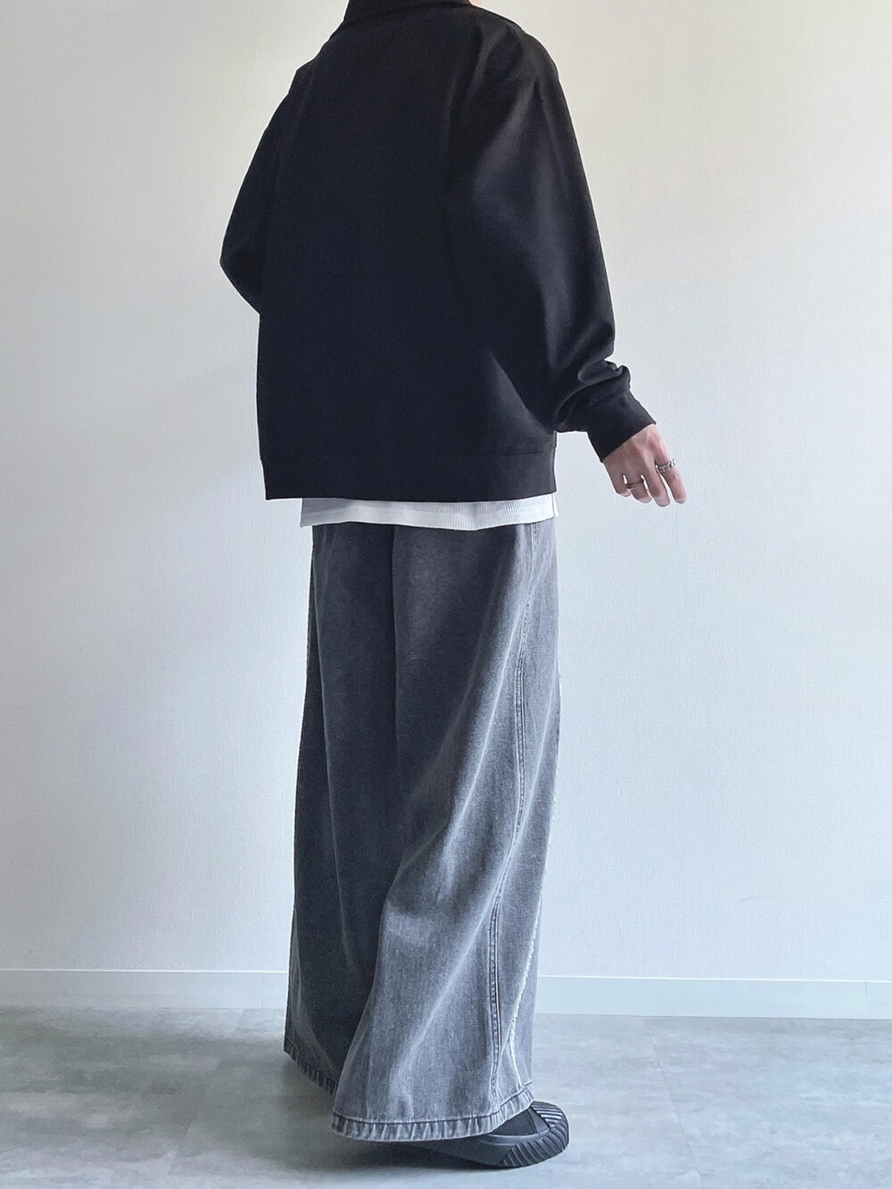 ブラック系のスウェット、ホワイト系のタンクトップ、グレー系のデニムパンツを着用したメンズの春コーディネートの4枚目の写真