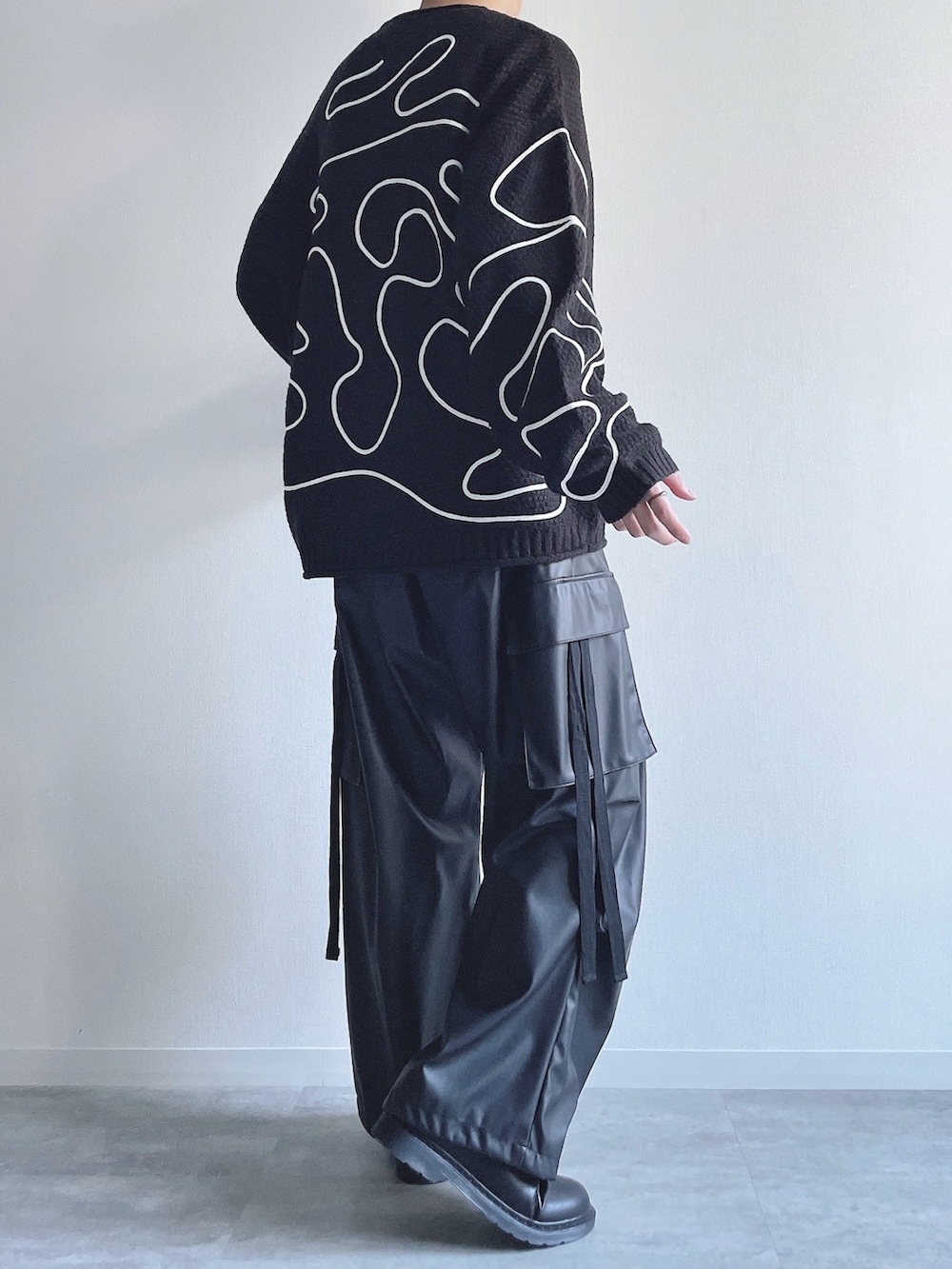 ブラック系のニット/セーター、ブラック系のカーゴパンツ、ブラック系のシューズを着用したメンズの冬コーディネートの4枚目の写真