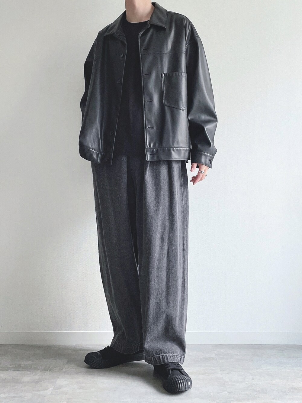 ブラック系のブルゾン、ブラック系のTシャツ/カットソー、ブラック系のデニムパンツを着用したメンズの秋コーディネートの2枚目の写真