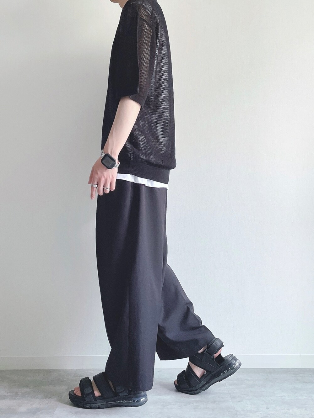 ブラック系のトップス、ホワイト系のタンクトップ、ブラック系のスラックスを着用したメンズの夏コーディネートの3枚目の写真