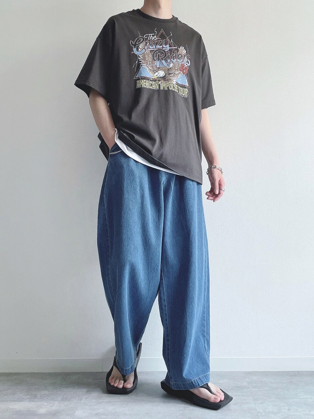 ブラック系のTシャツ/カットソー、ホワイト系のタンクトップ、ブルー系のデニムパンツを着用したメンズの夏コーディネートの3枚目の写真
