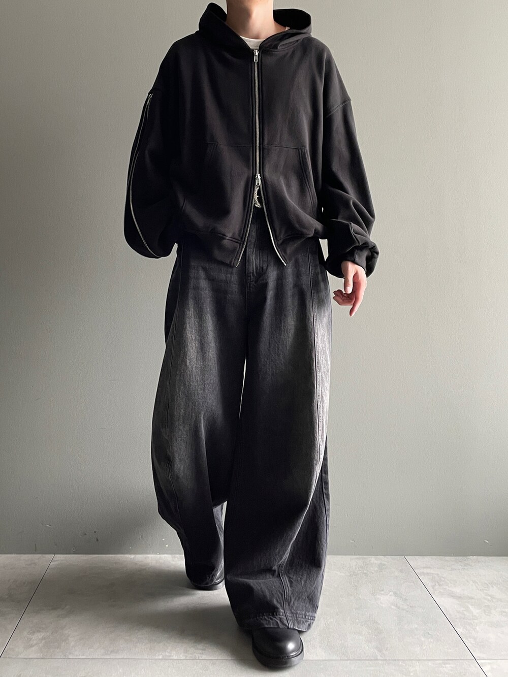 ブラック系のパーカー、ブラック系のデニムパンツ、ホワイト系のTシャツ/カットソーを着用したメンズの冬コーディネートの4枚目の写真