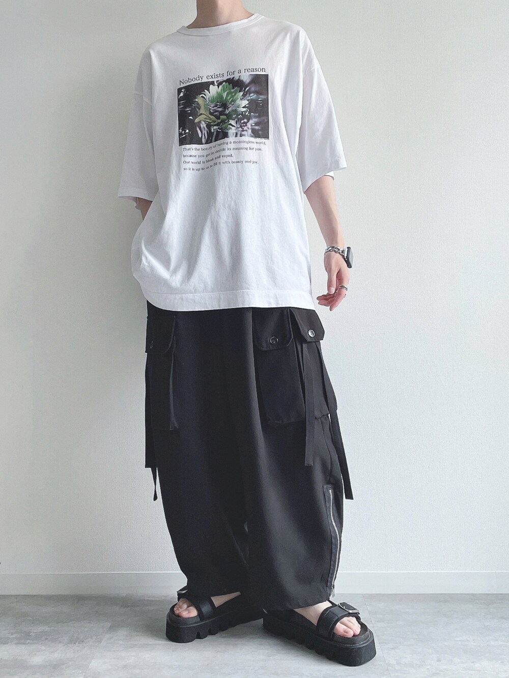 ホワイト系のTシャツ/カットソー、ブラック系のカーゴパンツ、ブラック系のサンダルを着用したメンズの夏コーディネートの5枚目の写真