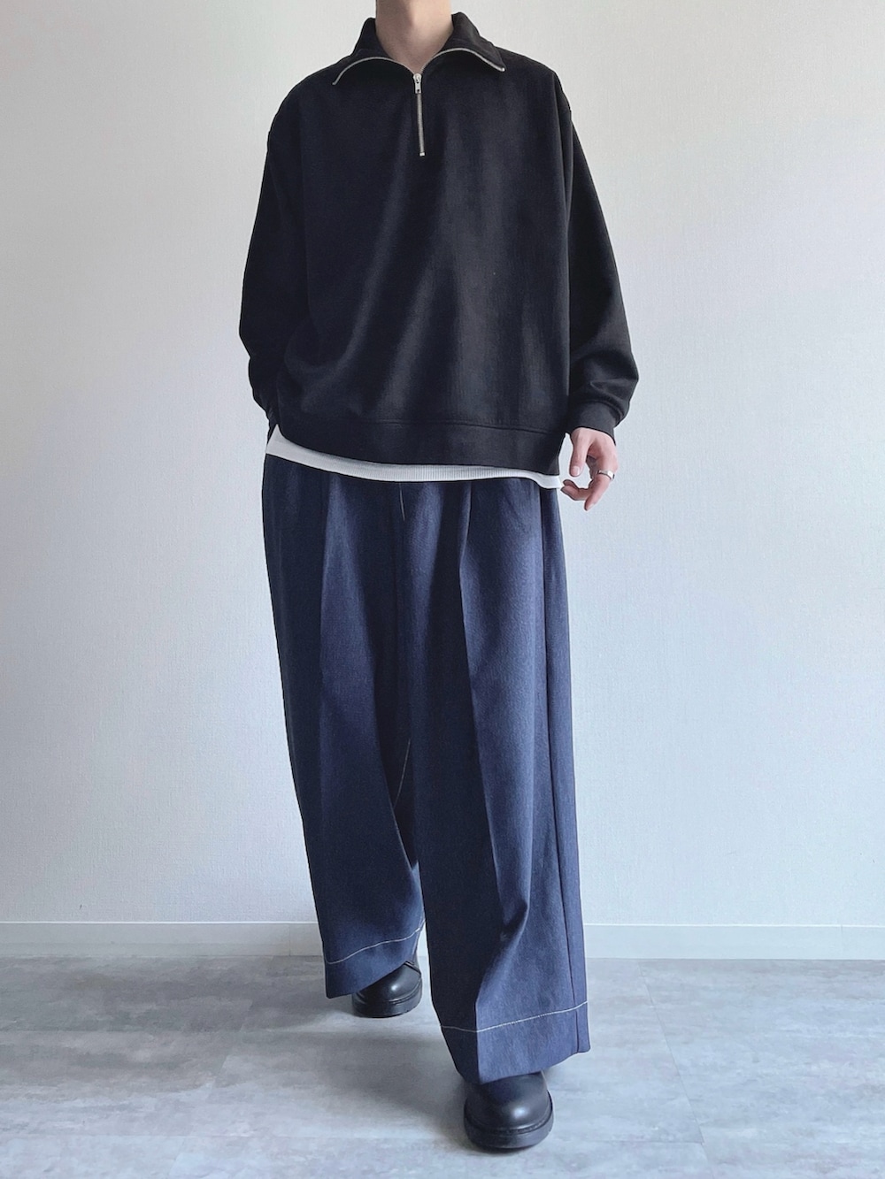 ブラック系のスウェット、ホワイト系のタンクトップ、ブルー系のデニムパンツを着用したメンズの春コーディネートの2枚目の写真