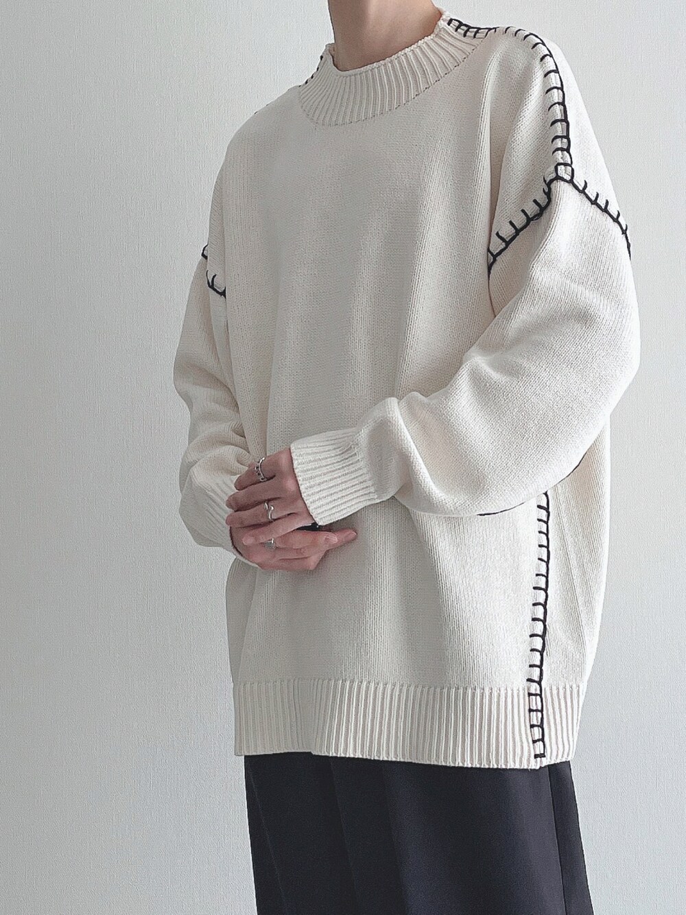 ホワイト系のニット/セーター、ブラック系のスラックス、ブラック系のドレスシューズを着用したメンズの秋コーディネートの5枚目の写真