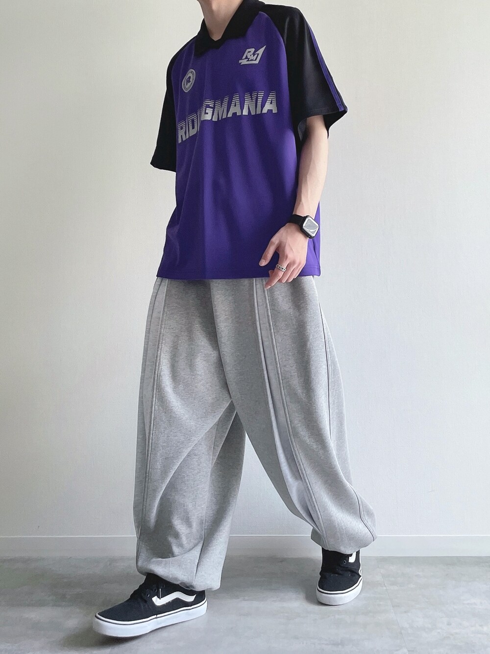 パープル系のTシャツ/カットソー、グレー系のパンツ、ブラック系のスニーカーを着用したメンズの秋コーディネートの5枚目の写真