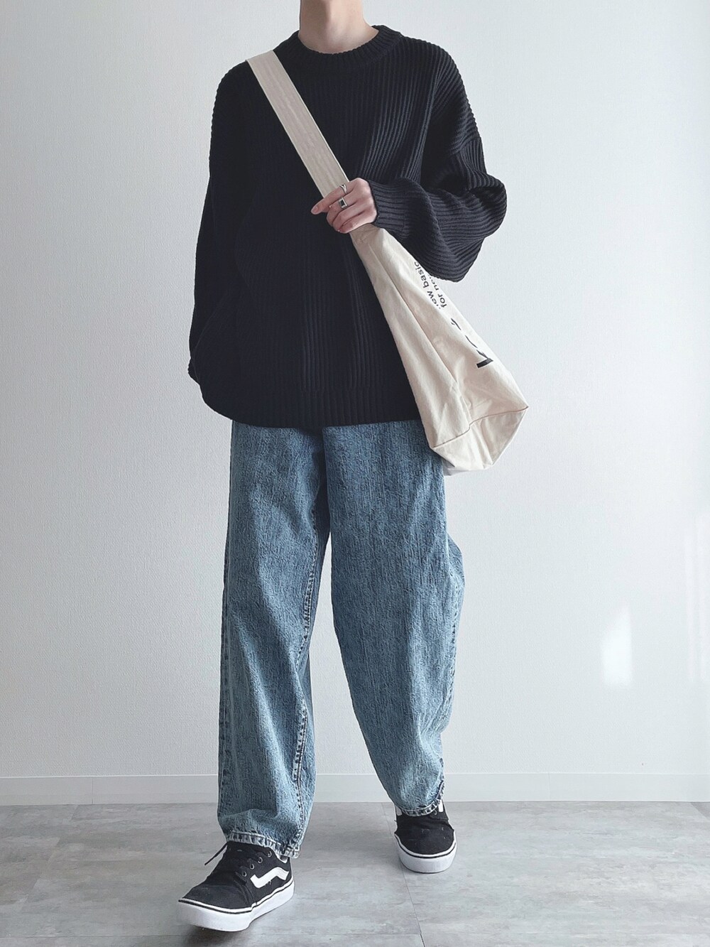 ブラック系のニット/セーター、ブルー系のパンツ、ブラック系のスニーカーを着用したメンズの冬コーディネートの5枚目の写真