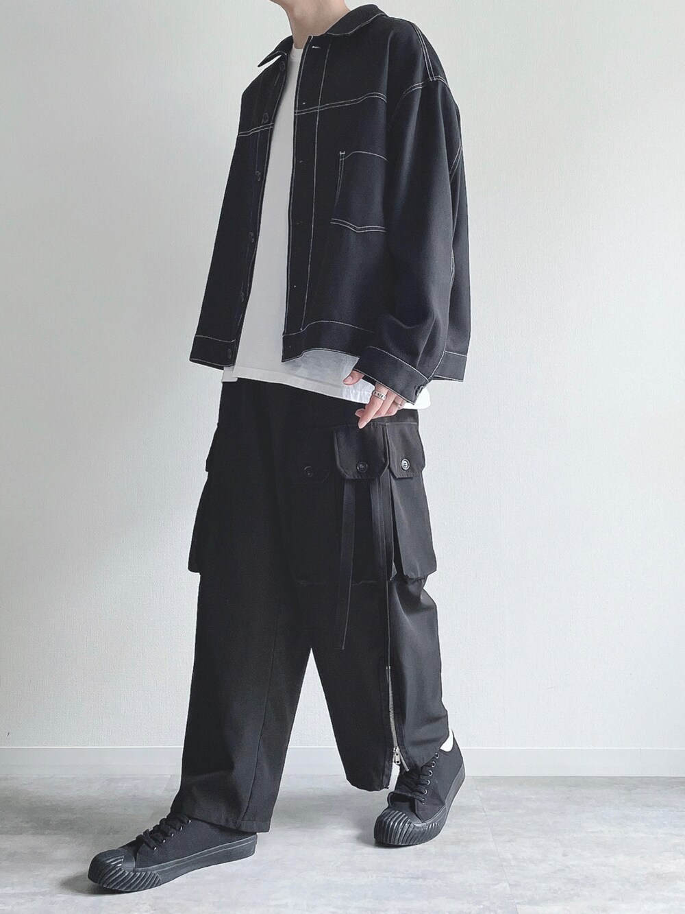 ブラック系のブルゾン、ホワイト系のTシャツ/カットソー、ブラック系のカーゴパンツを着用したメンズの秋コーディネートの5枚目の写真