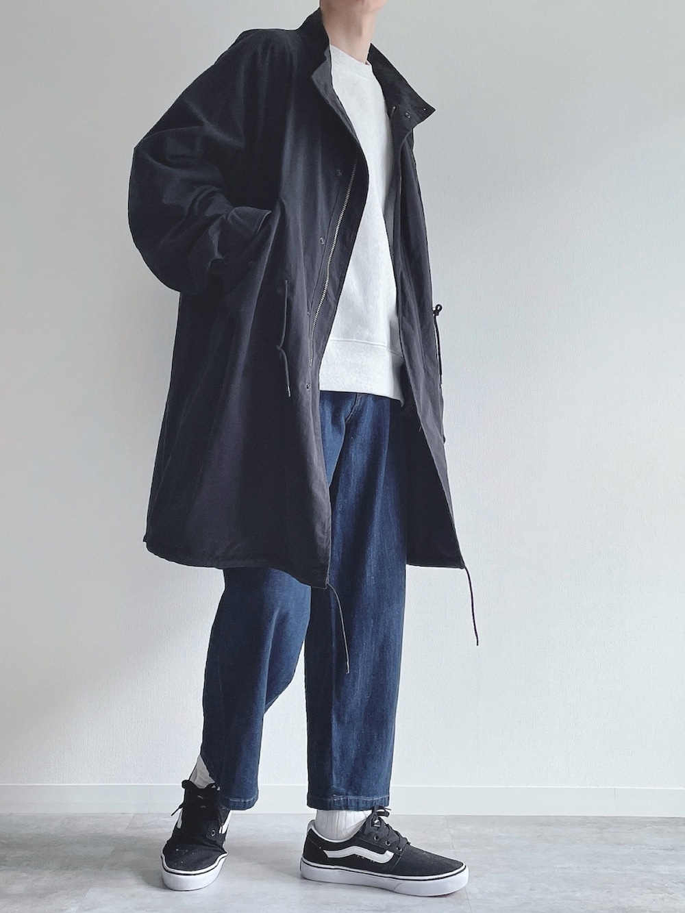 ブラック系のモッズコート、グレー系のトップス、ブルー系のその他パンツを着用したメンズの春コーディネートの2枚目の写真