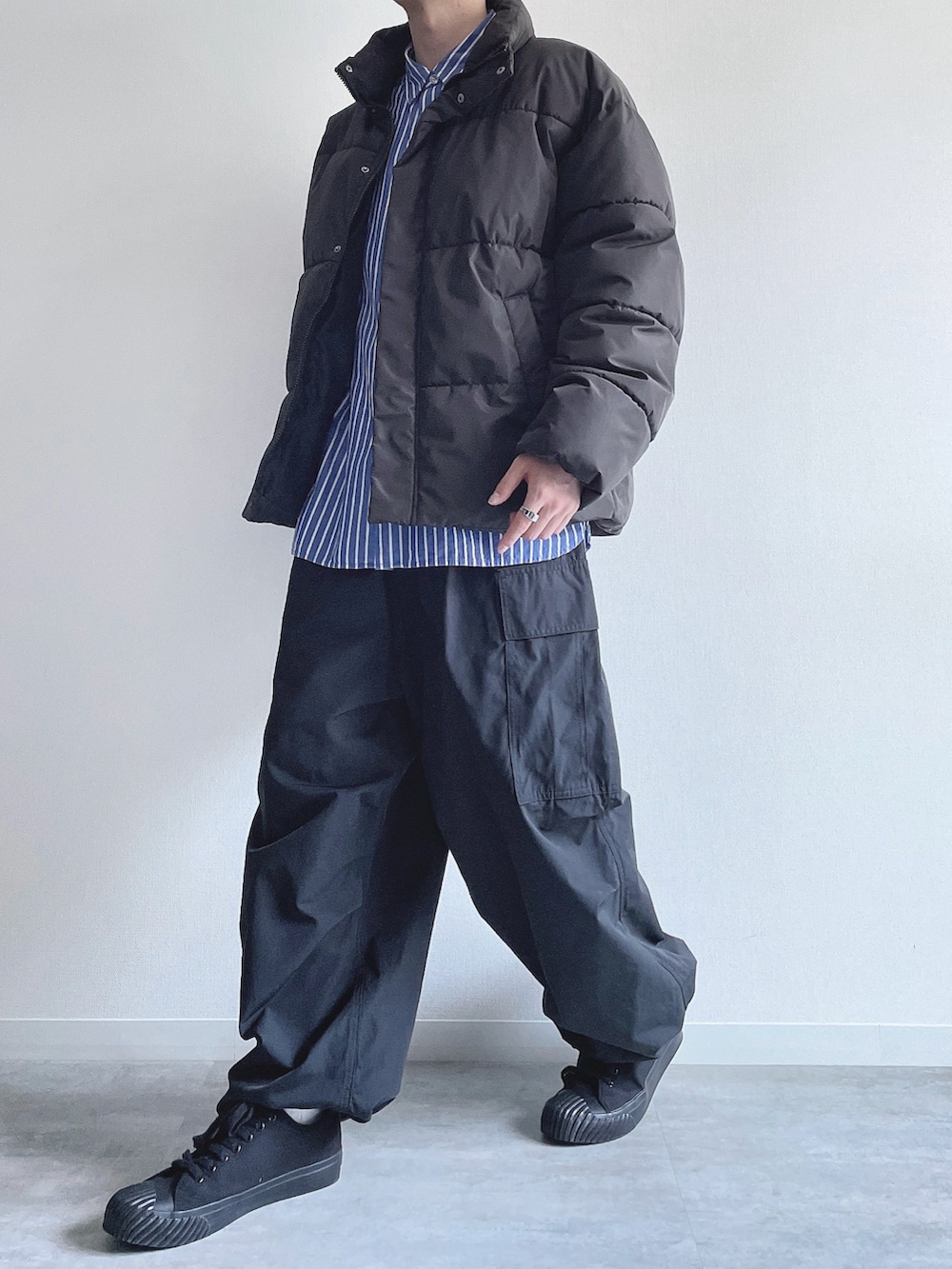 ブラック系のダウンジャケット/コート、ブルー系のシャツ/ブラウス、ブラック系のカーゴパンツを着用したメンズの冬コーディネートの3枚目の写真