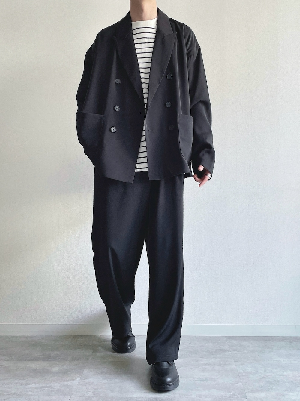 ブラック系のセットアップ、ホワイト系のTシャツ/カットソー、ブラック系のシューズを着用したメンズの春コーディネートの2枚目の写真