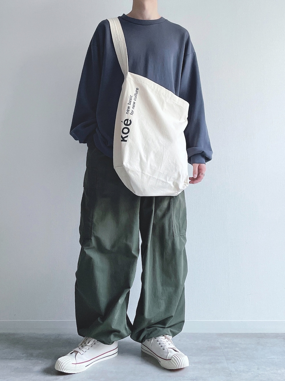 ブルー系のトップス、グリーン系のカーゴパンツ、ホワイト系のスニーカーを着用したメンズの秋コーディネートの5枚目の写真