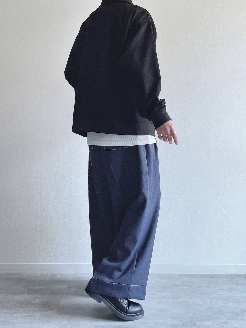 ブラック系のスウェット、ホワイト系のタンクトップ、ブルー系のデニムパンツを着用したメンズの春コーディネートの4枚目の写真