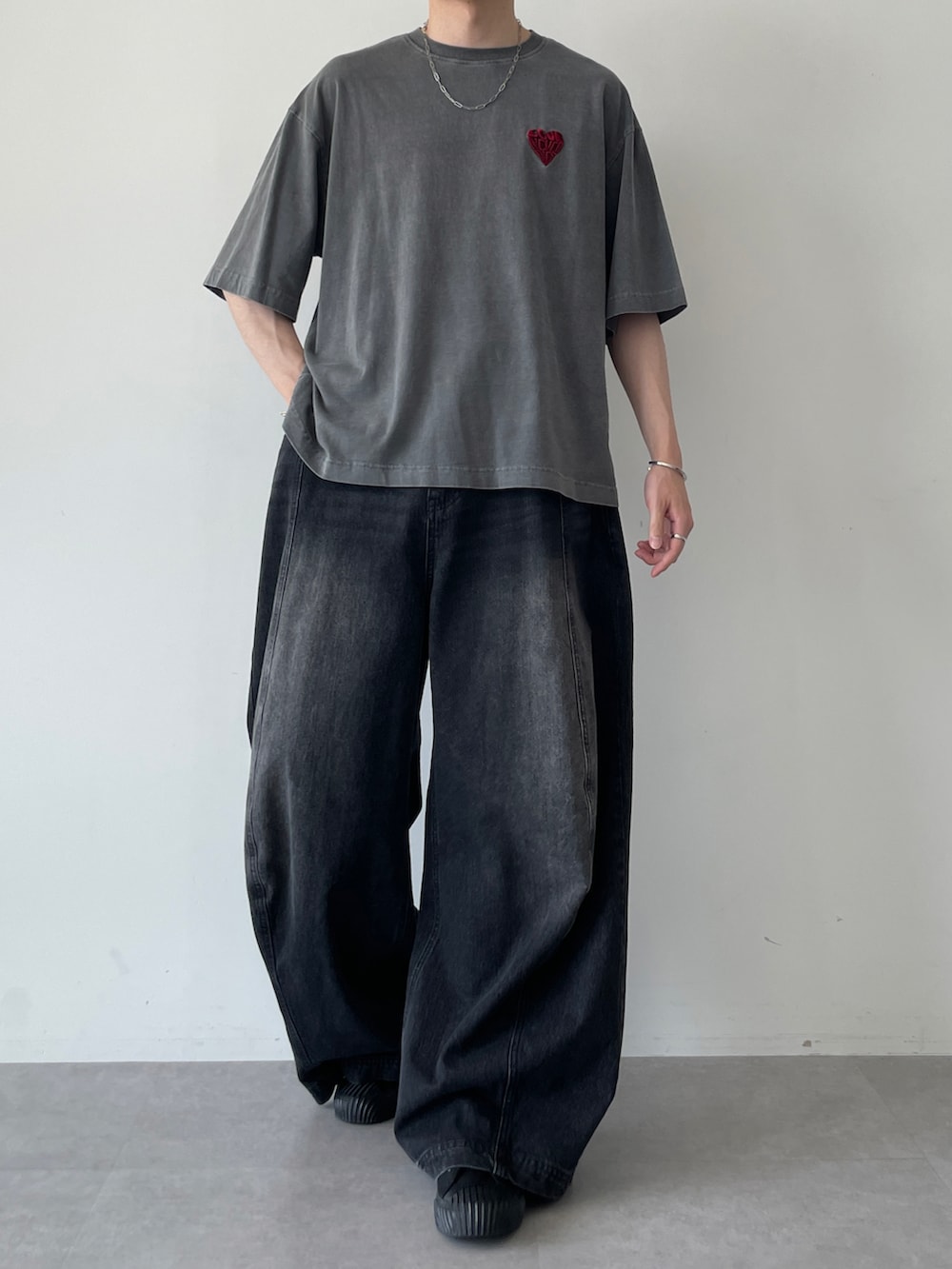 ブラック系のTシャツ/カットソー、ブラック系のデニムパンツ、ブラック系のスニーカーを着用したメンズの夏コーディネートの2枚目の写真