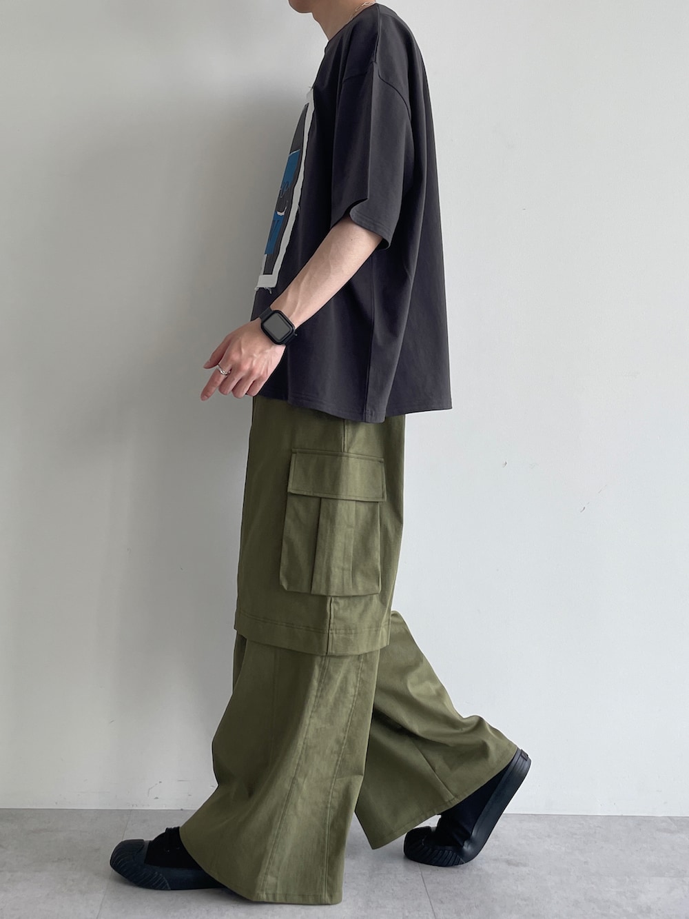 グリーン系のカーゴパンツ、ブラック系のスニーカー、グレー系のTシャツ/カットソーを着用したメンズの夏コーディネートの3枚目の写真