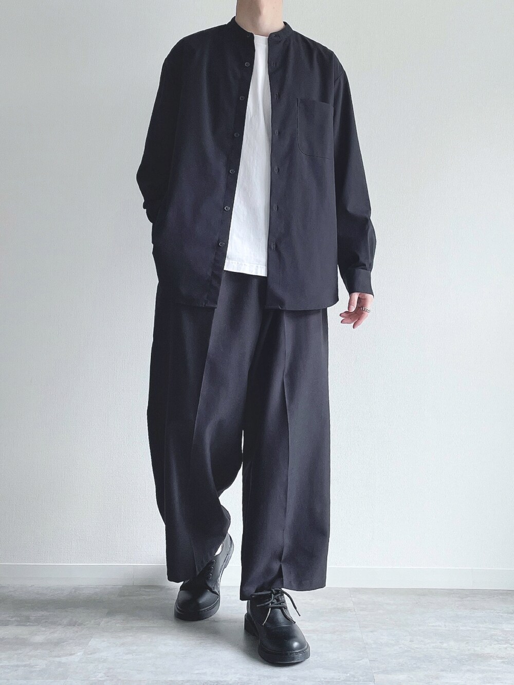 ブラック系のトップス、ホワイト系のTシャツ/カットソー、ブラック系のスラックスを着用したメンズの春コーディネートの2枚目の写真