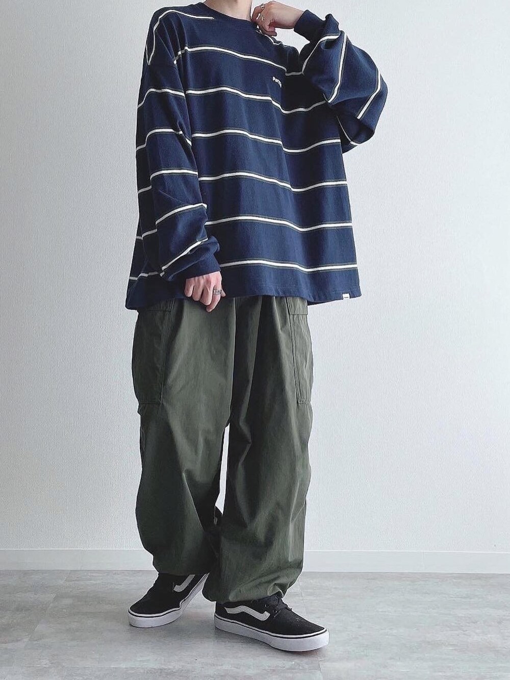 ブルー系のTシャツ/カットソー、グリーン系のカーゴパンツ、ブラック系のスニーカーを着用したメンズの秋コーディネートの5枚目の写真