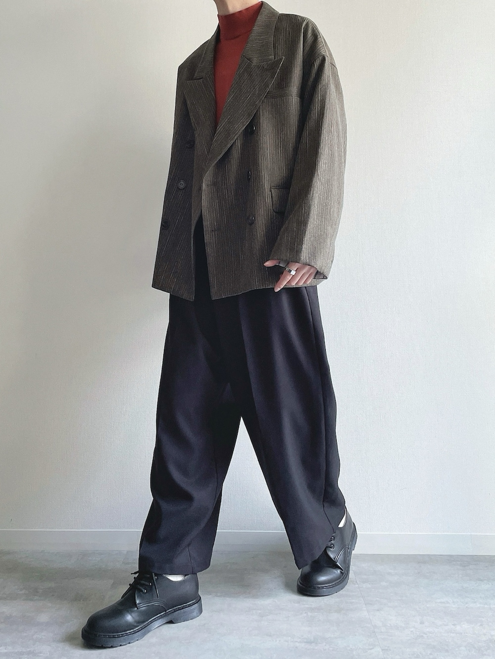 グリーン系のテーラードジャケット、レッド系のニット/セーター、ブラック系のスラックスを着用したメンズの冬コーディネートの5枚目の写真